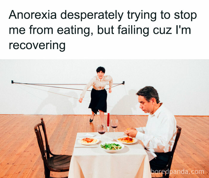 Man dining with salads and pasta, while a person behind him is tied with elastic bands. Text about recovering from anorexia. Mental health meme.