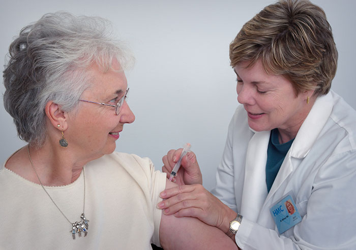 Elderly woman receiving a vaccine injection from a healthcare worker, illustrating deeply disturbing secrets revealed theme.