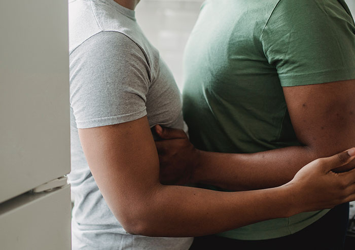 Two people embracing closely indoors, capturing the emotional impact of disturbing secrets revealed about someone close.