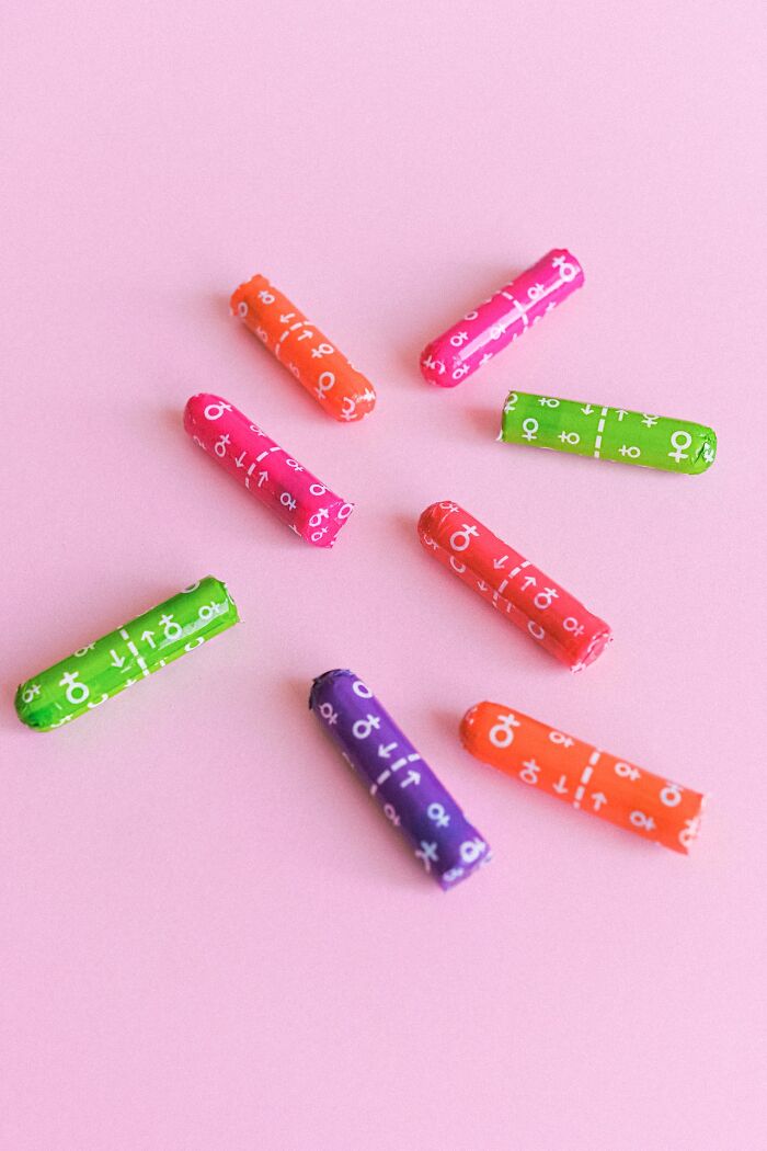 Colorful wrapped tampons arranged on pink surface illustrating things people have learned never to buy cheap.