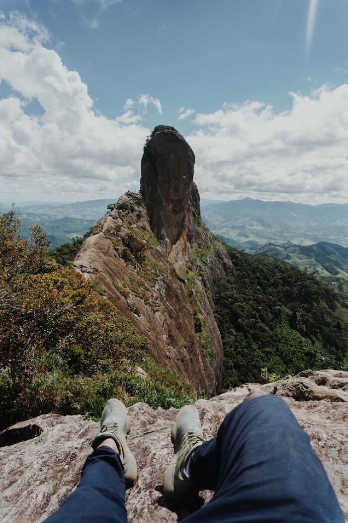 View from a rocky mountaintop showing a lone peak and expansive forest landscape while exploring the great outdoors.