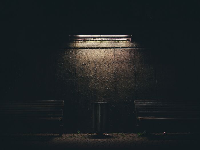 Trash Bin And Couple Of Benches On A Light In A Night 
