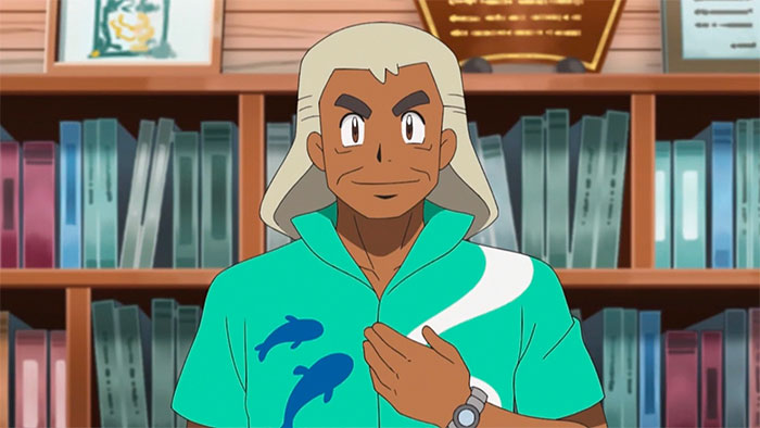 Samson Oak in an ocean-green shirt, stands in front of a bookshelf - 85