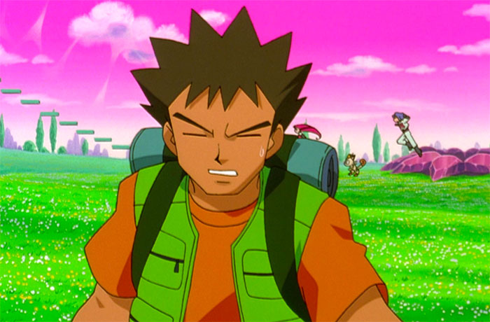 Brock Harrison is walking with his backpack in a green field with a pink sky in the background - 3