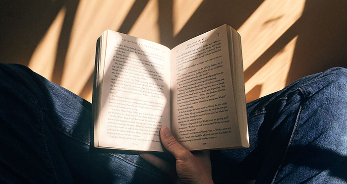 Man sitting and holding a book