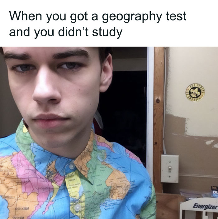 Young man wearing a world map shirt looking serious, representing a funny science meme on geography test struggles.