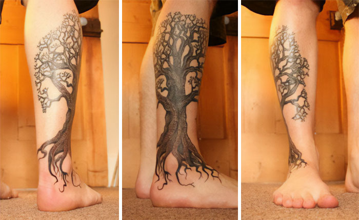 Lower leg with a majestic tree tattoo, showcasing intricate branches and roots, celebrating nature's wonders.