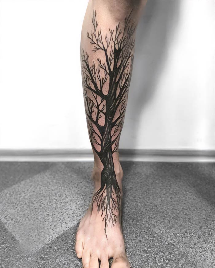 Majestic tree tattoo design on leg, showcasing intricate branches and roots.