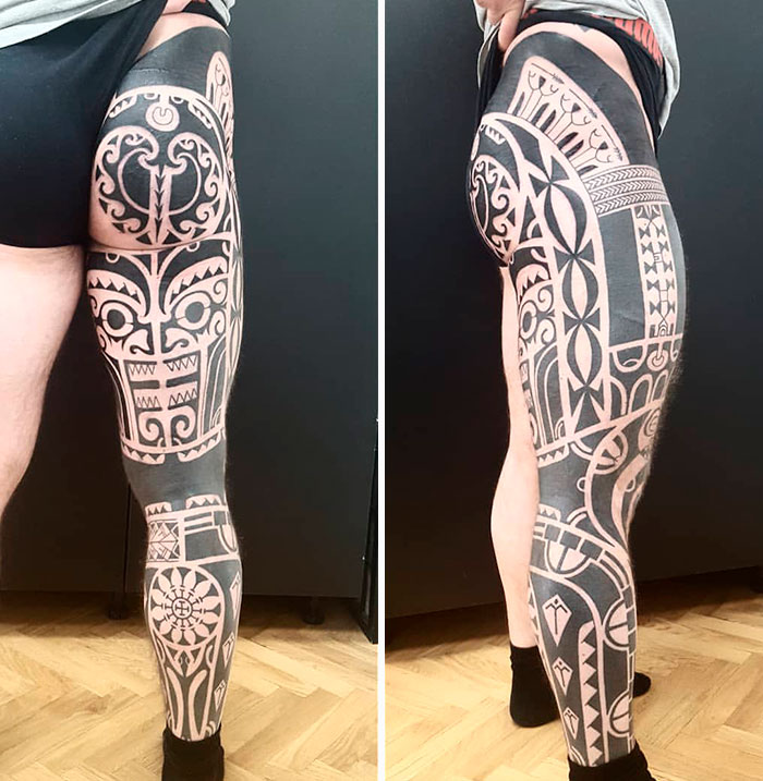 Detailed tribal tattoo design on a person's leg, showcasing intricate patterns and shapes.