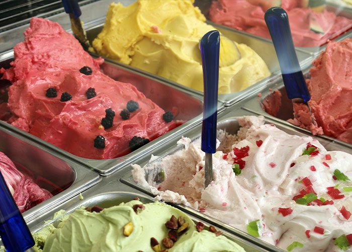 Various colorful gelato flavors in metal trays with blue-handled scoops, highlighting unique college courses related to food studies.