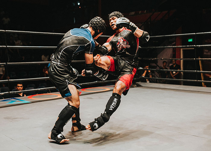Two martial artists sparring in a ring, demonstrating skills related to unique college courses in martial arts.
