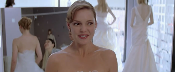 Scene from 27 Dresses movie featuring a bride in a wedding dress, highlighting the best wedding movies ever made.