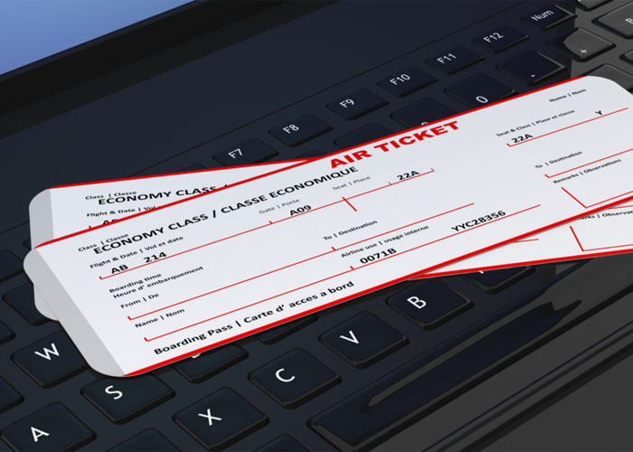 Two economy class air tickets placed on a laptop keyboard, illustrating a paid trip dispute to Hawaii.