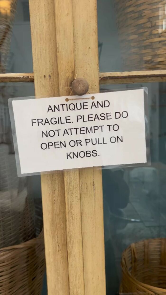 Sign with Airbnb rules warns guests not to open or pull on knobs to protect fragile antique furniture.