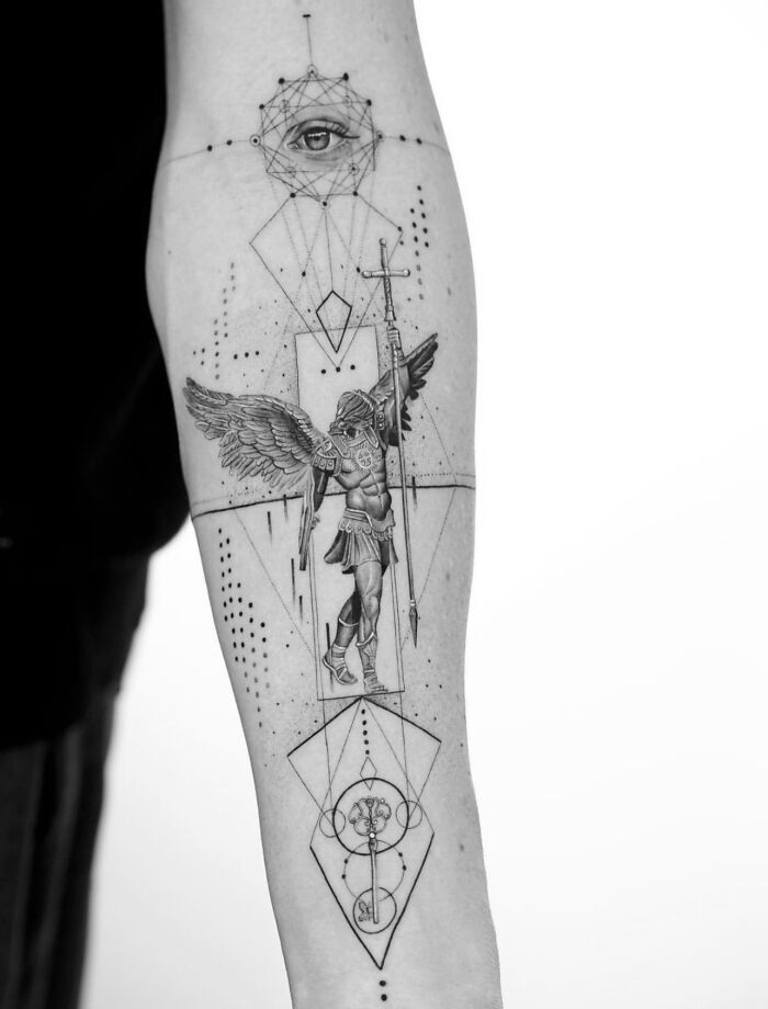 Geometric tattoo on arm featuring an angel with a spear and intricate patterns.