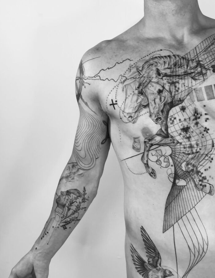 Man with intricate geometric tattoo sleeve and chest design, showcasing a talented tattoo artist's work.