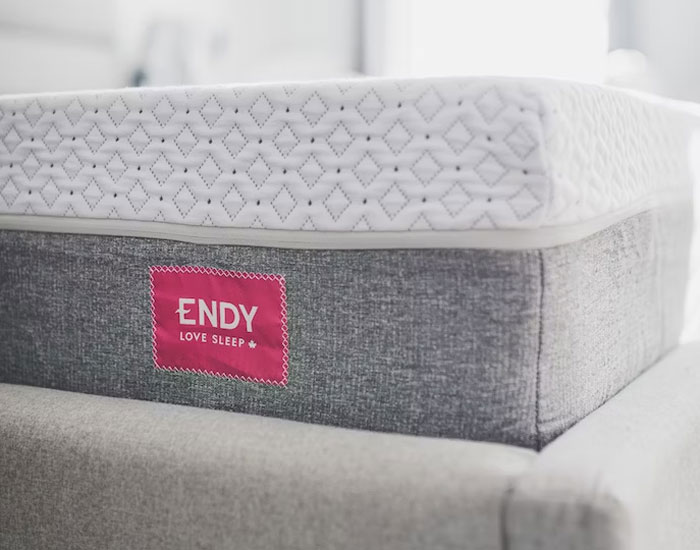 Close-up of an Endy mattress with gray fabric and white quilted top, illustrating common urban legends about sleep facts.