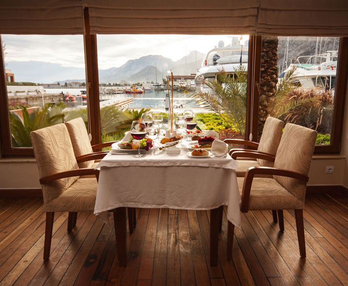Romantic first date setup with table for two overlooking marina, related to man acting strange and woman blocking him.