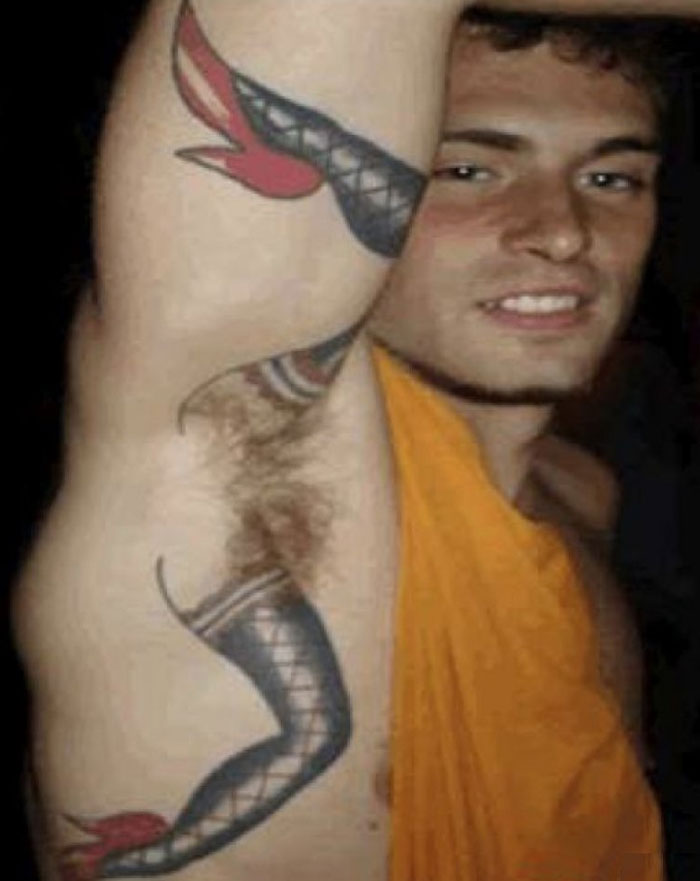 Man showing off a tattoo of high heels and stockings on his armpit.