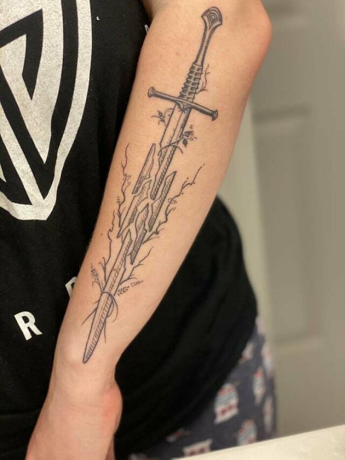 Arm tattoo of a sword inspired by Lord of the Rings.
