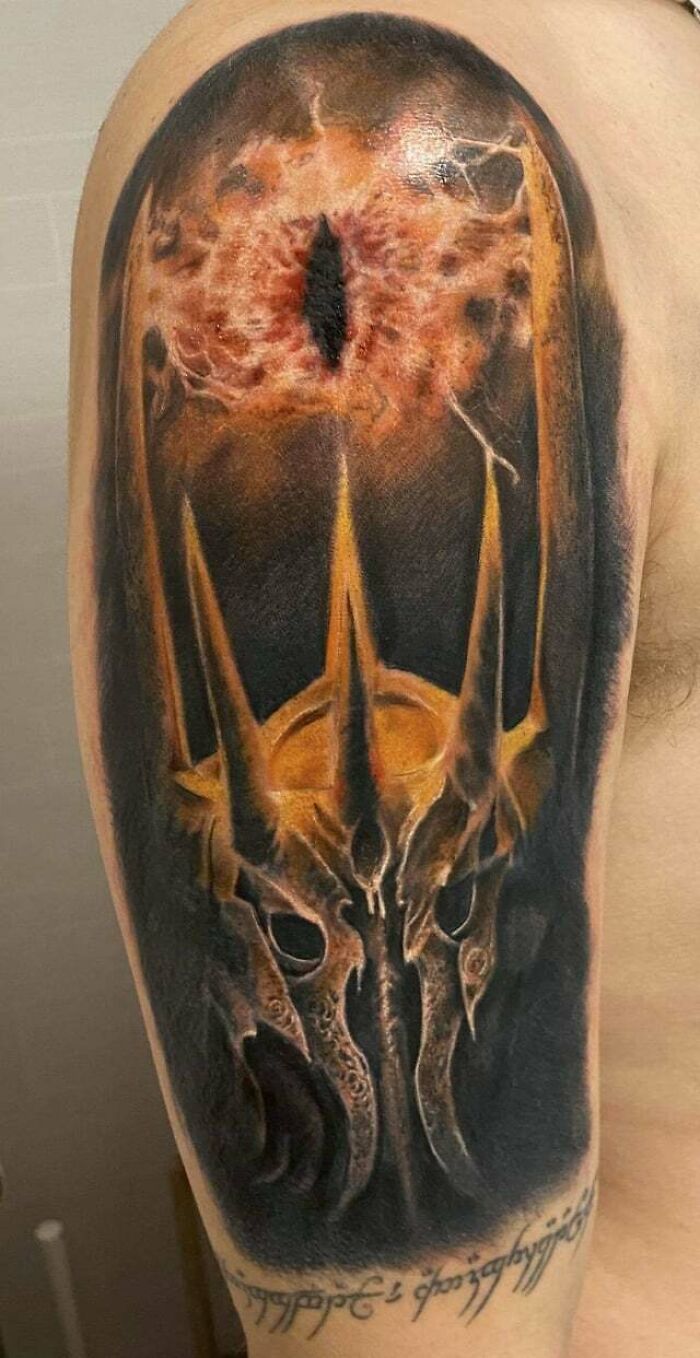 Lord of the Rings tattoo featuring Sauron's eye and helm design on an arm.