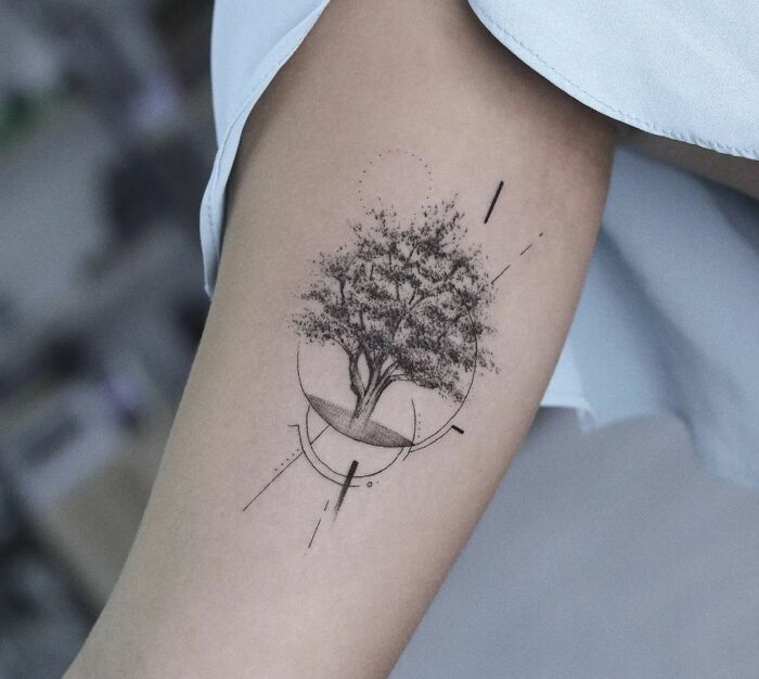 Minimalistic majestic tree tattoo design on forearm, showcasing nature's beauty with geometric elements.