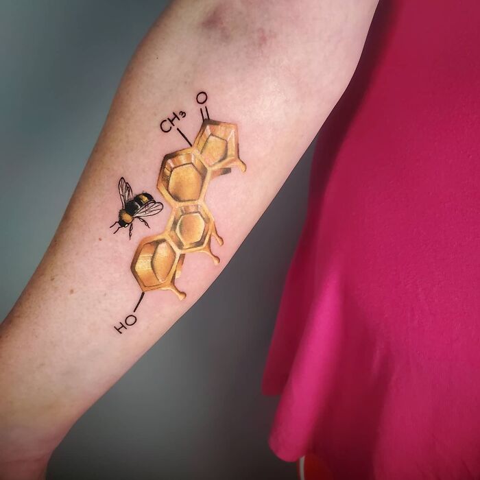 Science tattoo of a honeycomb chemical structure with a bee on an arm.