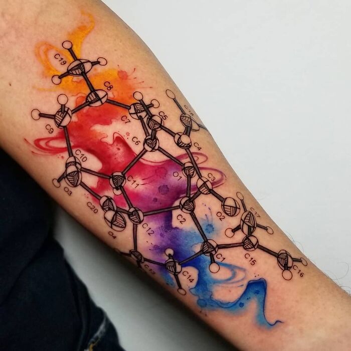 Colorful molecular structure tattoo on arm, showcasing science-themed art.