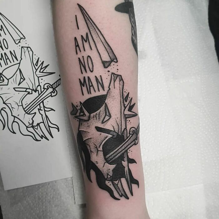Tattoo of the Witch-king's helmet with "I am no man" text, inspired by Lord of the Rings.