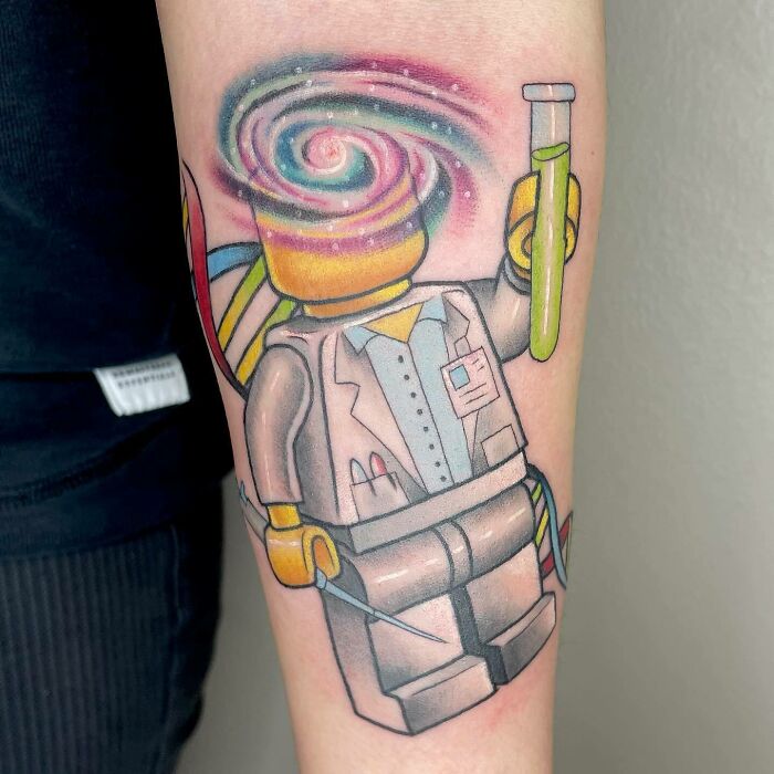 Lego scientist tattoo with vortex head and test tube, representing science passion.