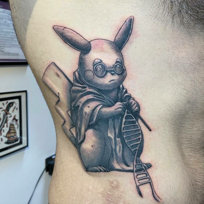 Tattoo of a creature holding a DNA strand, symbolizing science and creativity.