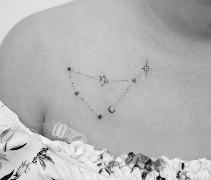 Zodiac tattoo featuring a Capricorn constellation with stars and crescent, inked on a person's shoulder.