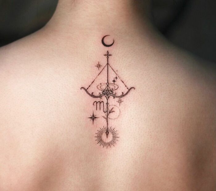 Intricate zodiac tattoo of Sagittarius with stars and crescent moon on upper back.