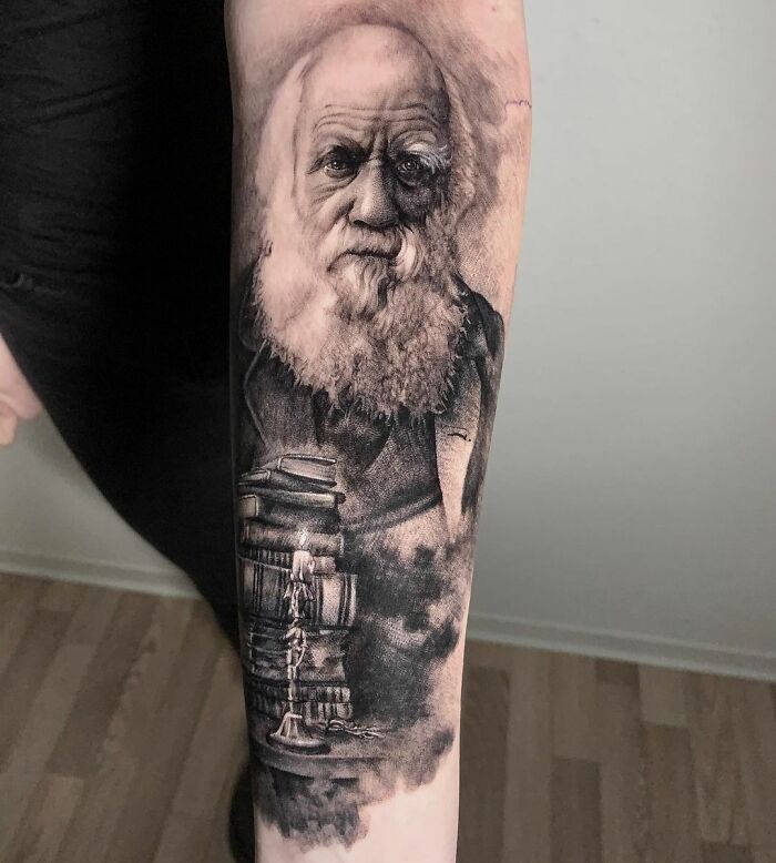 A detailed science tattoo featuring a portrait with books and a candle.