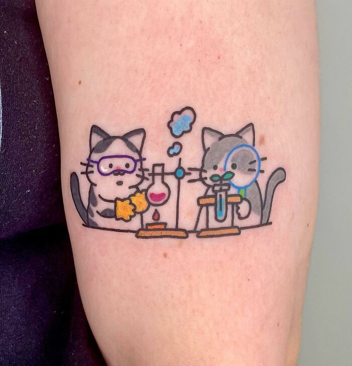 Cartoon cats conducting an experiment tattoo for science enthusiasts.