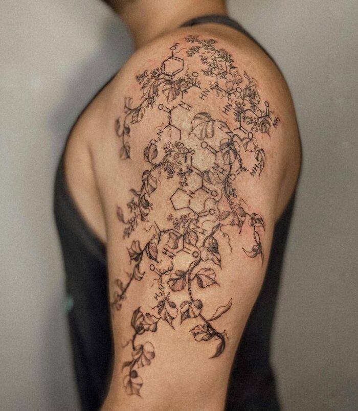 Science tattoo with molecular structures and botanical elements on a person's upper arm.