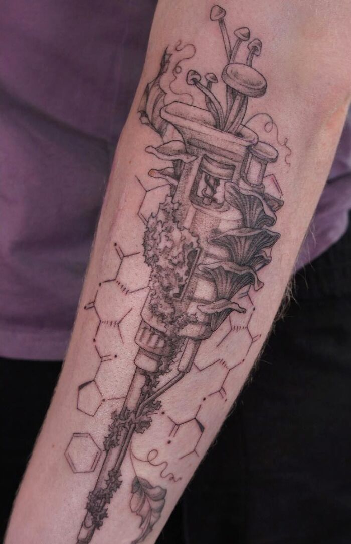 Arm with a detailed science tattoo, featuring a microscope and molecular structures.