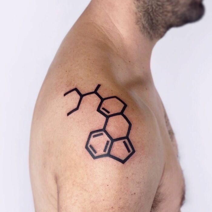 Tattoo of a chemical structure on a man's shoulder, showcasing a unique science-inspired design.