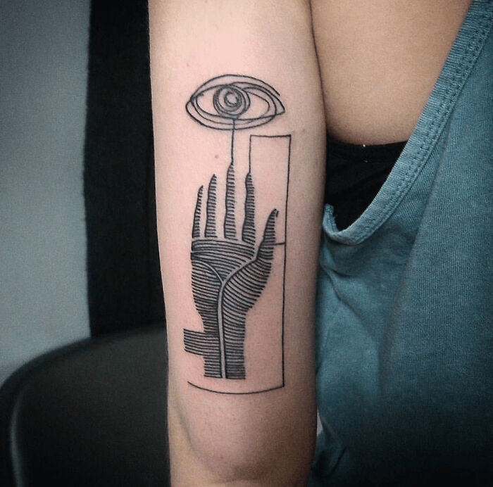 Abstract tattoo design on an arm featuring a hand and eye symbol, showcasing artistry and self-expression.