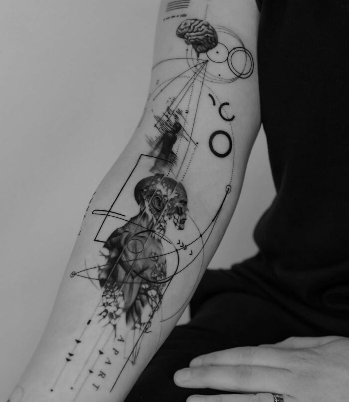 Abstract science tattoo on a person's forearm, featuring anatomical and geometric designs.