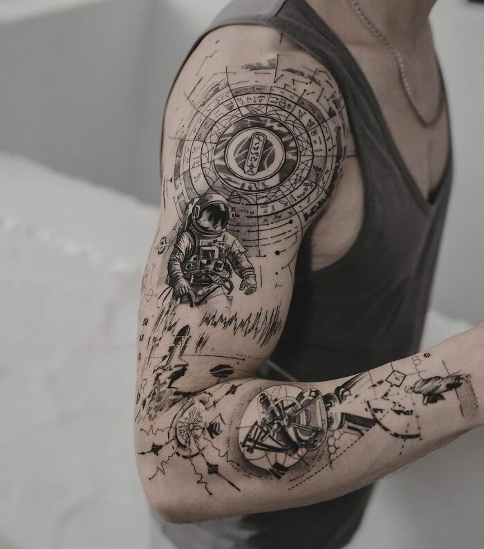 Science tattoos featuring astronaut and space motifs on a person's arm.