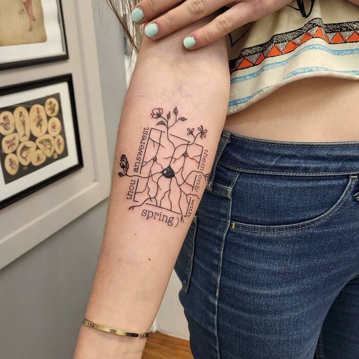 Forearm tattoo with scientific design, featuring a plant and words relating to science.