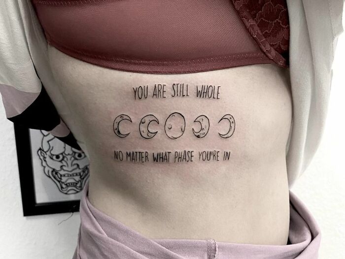 Tattoo of moon phases with a mental health message on the side, symbolizing healing and wholeness.