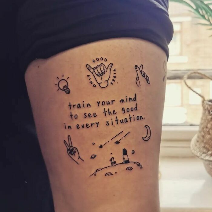 Tattoo reads "train your mind to see the good in every situation" with doodles, symbolizing mental health and healing.