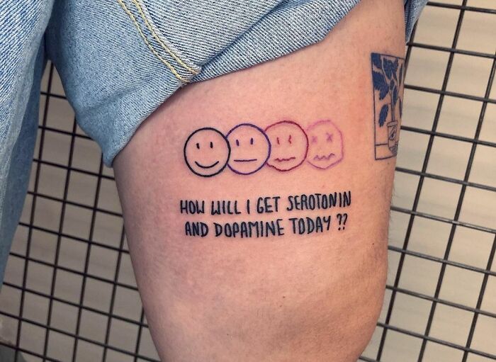 Tattoo on arm with four faces and text: "How will I get serotonin and dopamine today?" promoting mental health.