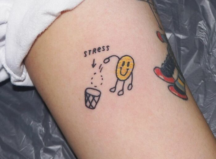 Smiley face tattoo discarding stress, symbolizing mental health healing.
