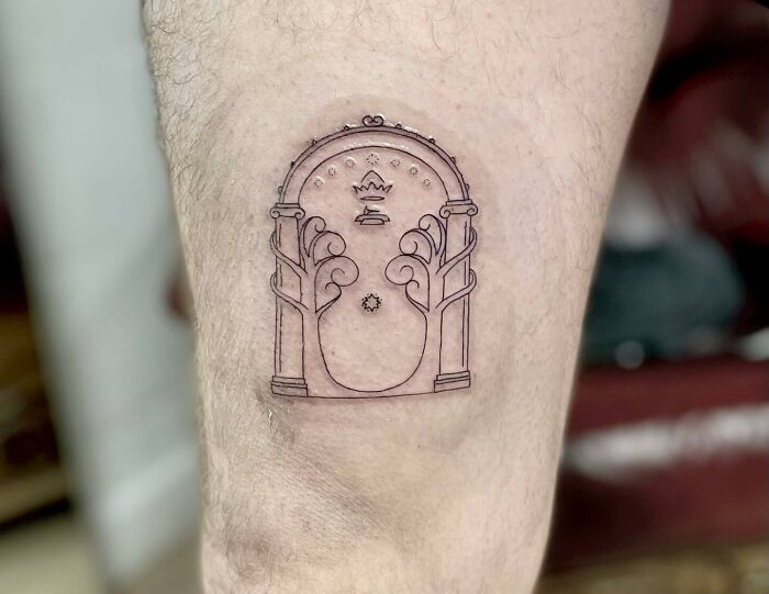 Minimalist Lord of the Rings tattoo featuring the Doors of Durin on a person's leg.