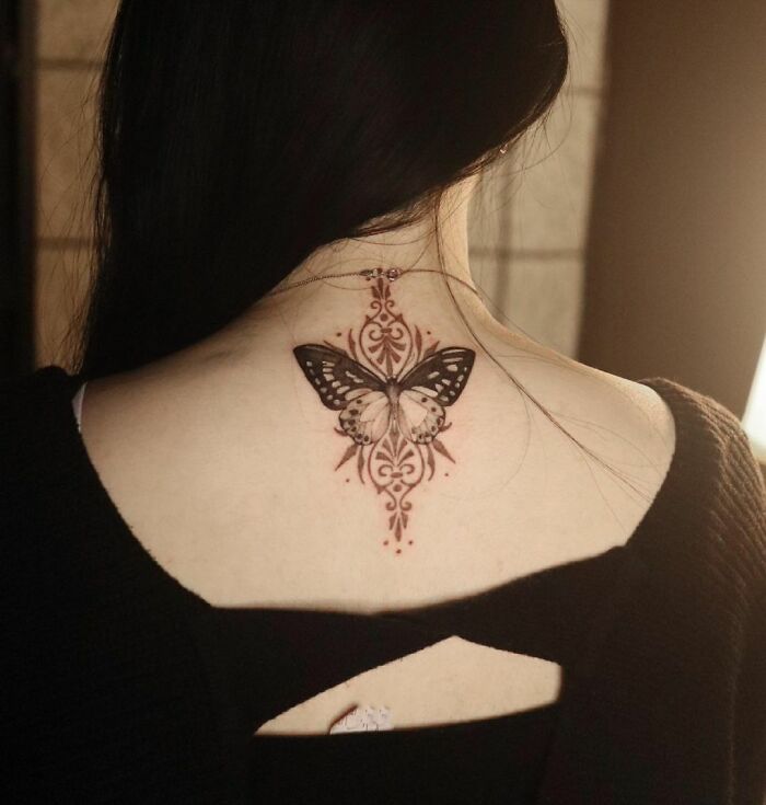 Butterfly tattoo on the back, featuring intricate designs and detailing.