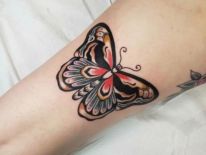 Colorful butterfly tattoo design on forearm, showcasing vibrant patterns and intricate details.