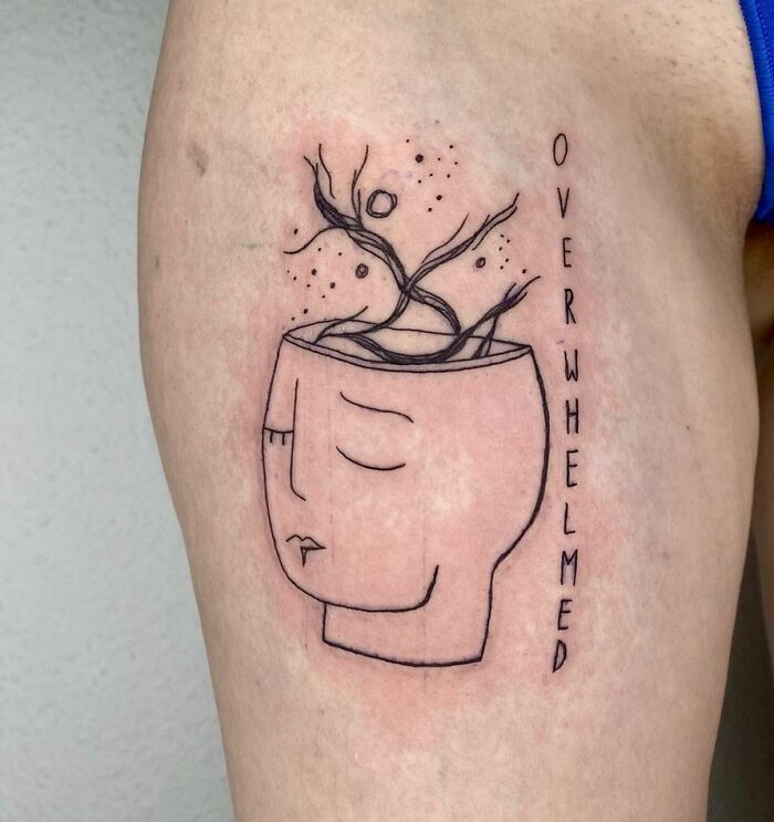 Minimalist mental health tattoo depicting a face with an open head and growing branches, symbolizing being overwhelmed.